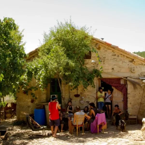 Comunidad sentada en la puerta de una vivienda colectiva en la ecoaldea Fraguas, en Guadalajara (Castilla-La Mancha)