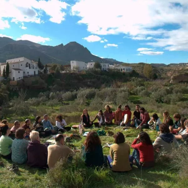 Personas sentadas en circulo en la naturaleza, junto al Cortijo Los Baños Al Hamam, Lucainena de las Torres, Almería (Andalucía) en España.
